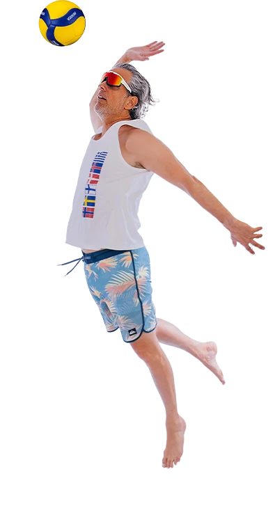 Mag. Erik Stadler springt dynamisch in die Luft und schlägt einen Volleyball über das Netz – sportlich, energiegeladen und voller Sommer-Feeling.