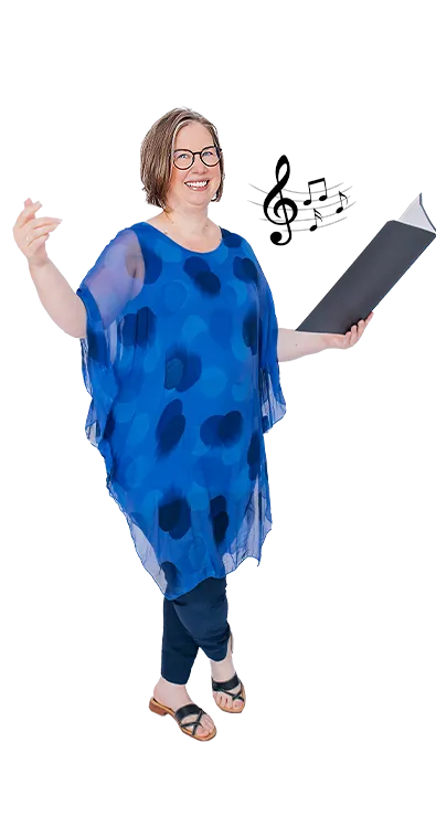 Mag. Irene Löffler mit offenem Notenordner und erhobener Hand in Dirigier-Pose – musikalisch, ausdrucksstark und voller Freude am Klang.