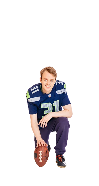 Jan-Michael Bussmann, MSc kniet im American-Football-Outfit mit einem Football in der Hand - sportlich, entschlossen und bereit für den nächsten Spielzug.
