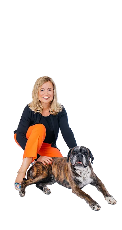 Dipl.-Kff. Dr. Verena Priemer kniet lächelnd neben einem braun-gestromten Hund, legt ihm die Hand auf den Rücken und strahlt Ruhe und Verbundenheit aus – tierlieb, herzlich und voller positiver Energie.